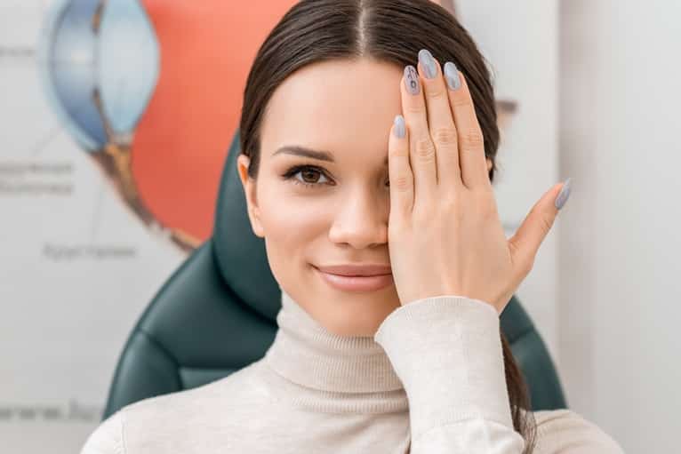 obscured view of young female patient getting eye test in clinic