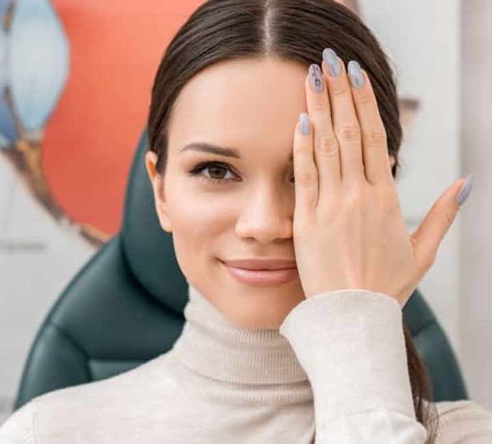 obscured view of young female patient getting eye test in clinic
